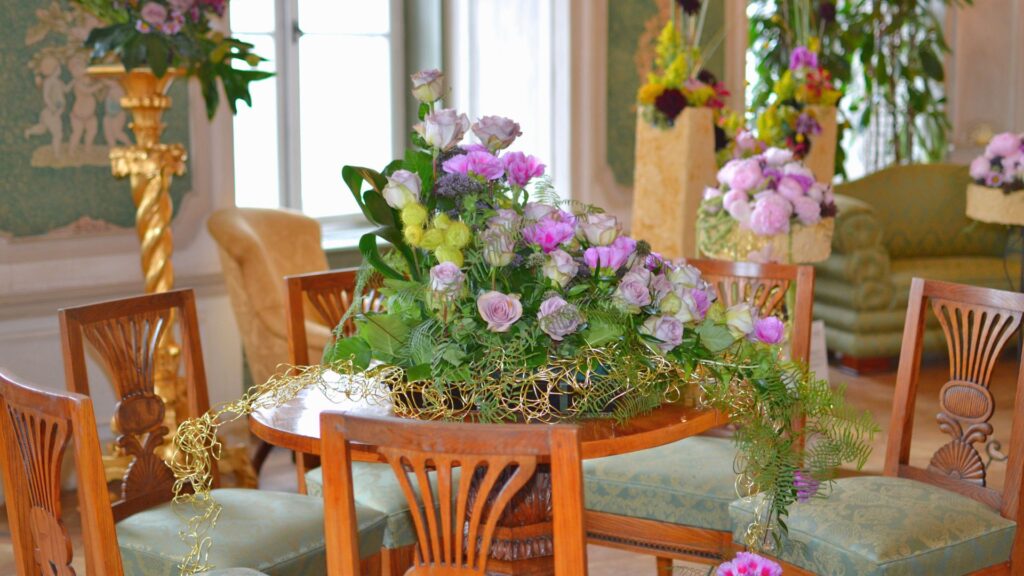 Arreglo floral colorido sobre mesa de madera representando creatividad rentable y emprendimiento artesanal.